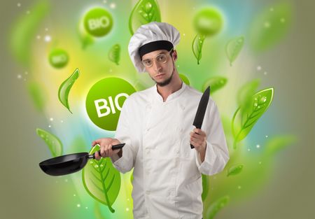 Green bio leaves concept and cook portrait with kitchen tools