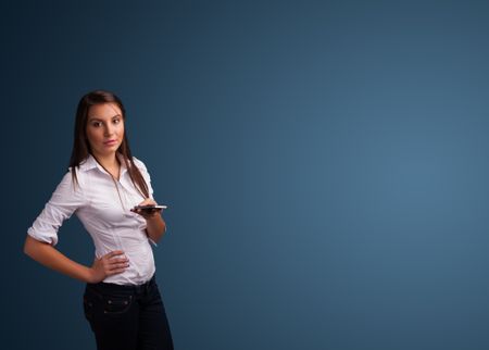 Pretty young woman standing and typing on her phone with copy space