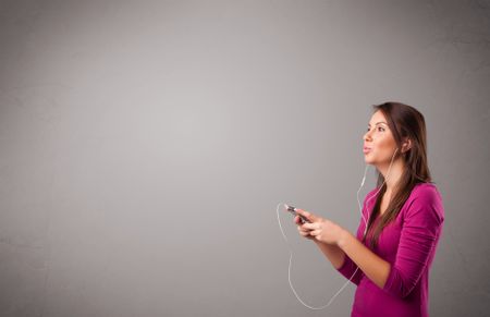 pretty young lady singing and listening to music with copy space