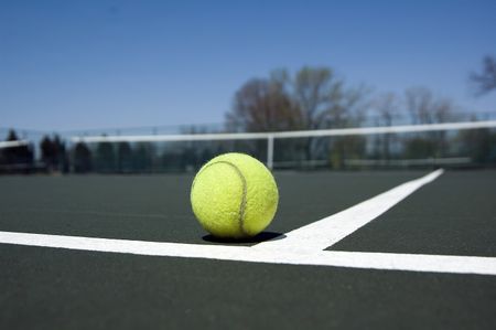 Eye-level view of tennis ball in corner of court