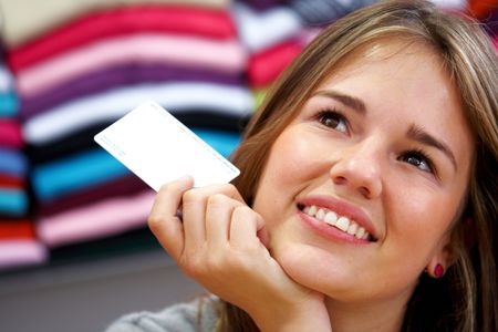woman smiling and holding a credit card in a shop