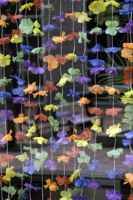 Spring strings: artificial flowers hang like a see-through curtain in a store window