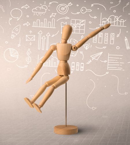 Wooden mannequin posed in front of a greyish background with white scribbled data around him