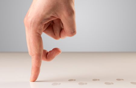 Female fingers walking with footsteps behind them 