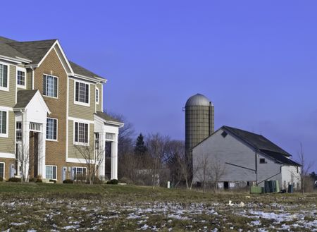 Contrast in lifestyles and architecture in northern Illinois: farm silo and barn of yesteryear near contemporary townhouse