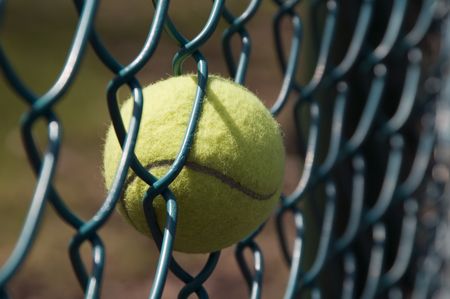 Tennis ball stuck in chainlink fence