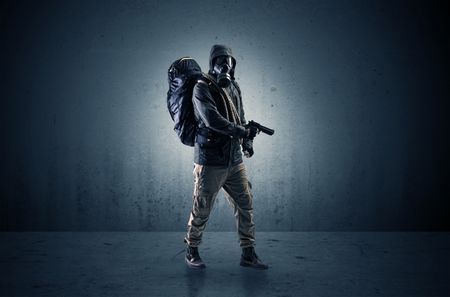 Bad agent in a dark room with arms on his hand and gas mask
