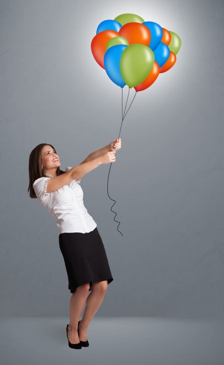 Pretty young woman holding colorful balloons