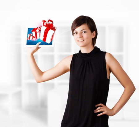 Young  woman looking at modern tablet with present boxes