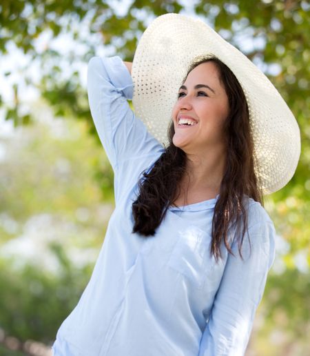 Happy woman in the countryside wearing a hat
