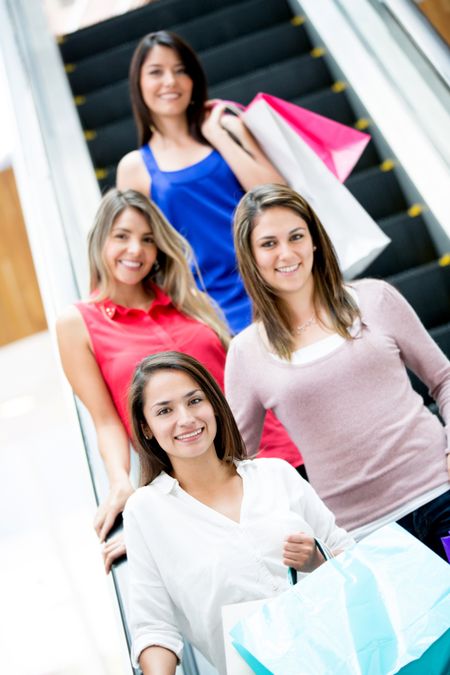 Happy women at the shopping center on the escalators