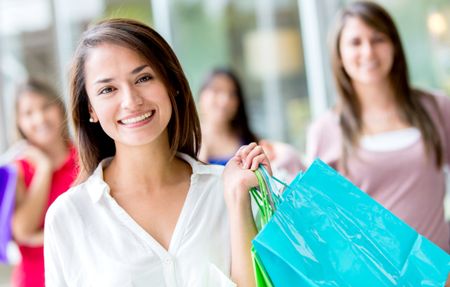 Beautiful female shopper holding bags and smiling