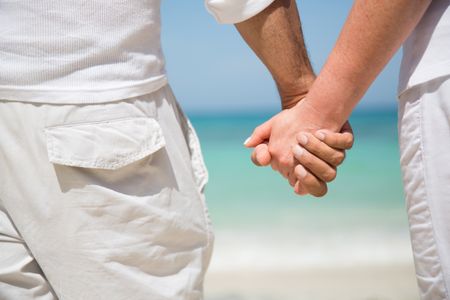 Loving couple holding hands at the beach