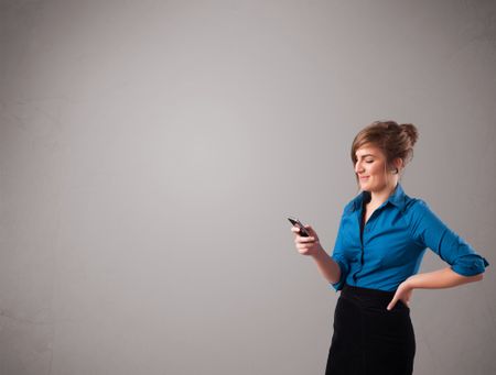 attractive-young-lady-standing-holding-phone-125751428 attractive young lady standing and holding a phone with copy space