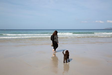 Woman and Dog on Beach in Galicia; Spain