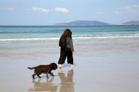 Woman and Dog on Beach in Galicia; Spain