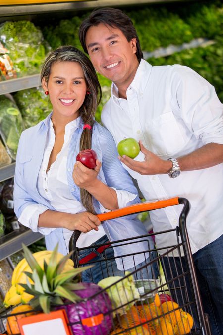 Happy couple grocery shopping at the supermarket