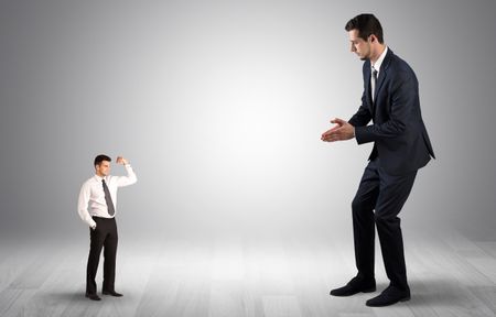 Big debutant young businessman scared of small strong businessman