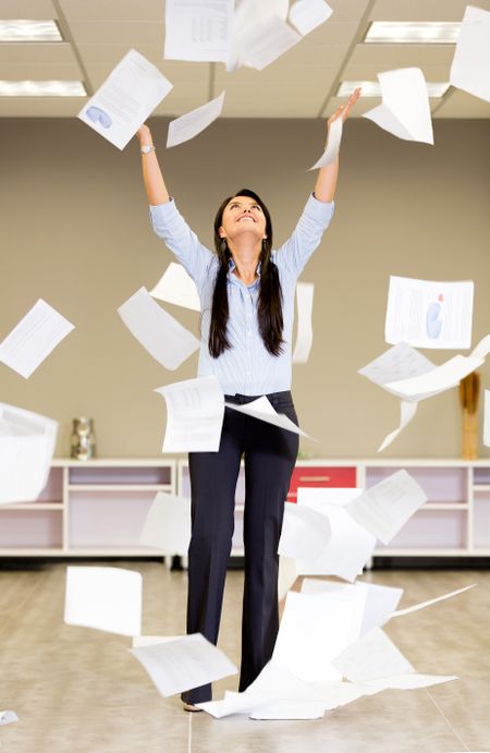 Successful businesswoman throwing papers in the air