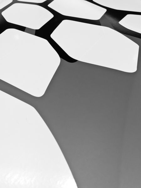Automotive abstract in black and white: Small portion of polygonal decal on hood of sporty car