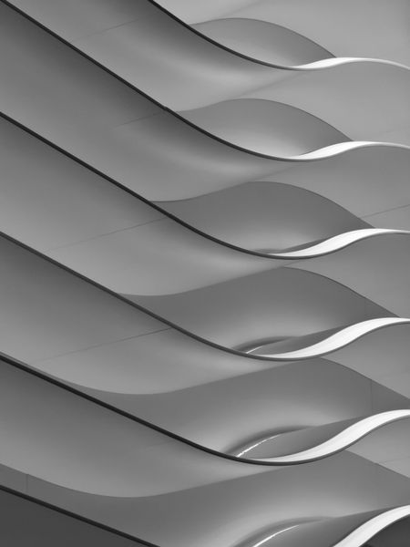 Abstract of interior design in black and white: Wavy wall with overhead lighting in public convention center