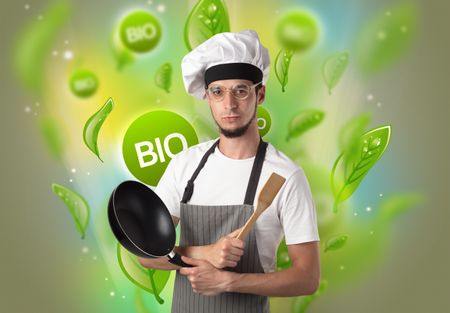 Green bio leaves concept and cook portrait with kitchen tools