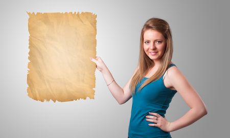 Beautiful young girl presenting old paper copy space