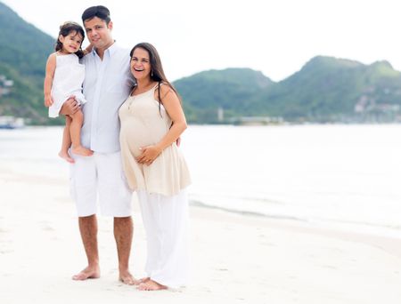 Beautiful family at the beach with pregnant woman