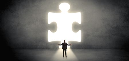 Businessman  standing and looking to a big puzzle piece