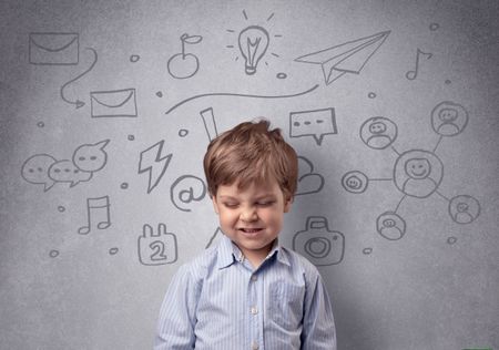 Smart little junior in front of a drawn up grey wall with childlike concept