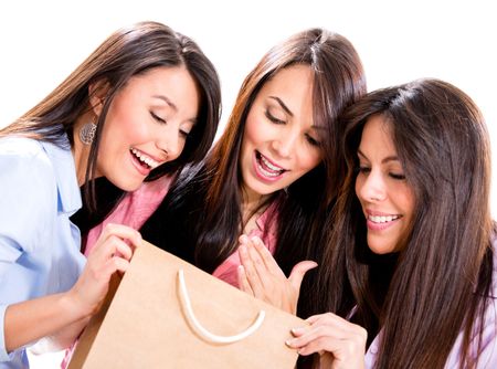 Happy group of shopping girls looking at their purchases - isolated over white