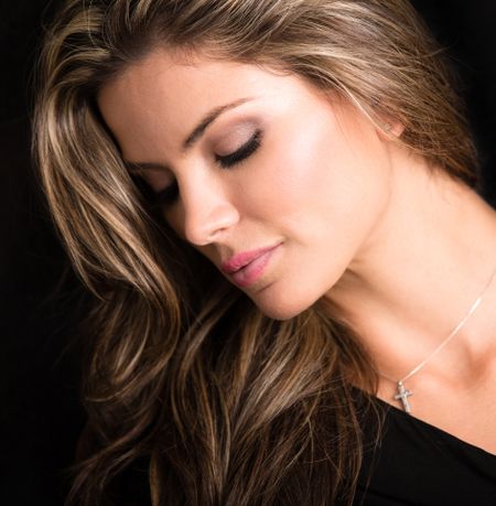 Portrait of a beautiful blond woman - isolated over black background