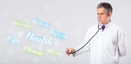 Elderly clinical doctor pointing to health and fitness collection of words