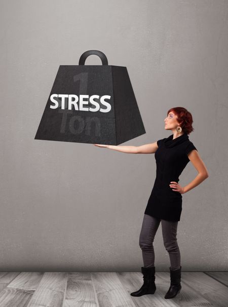 Attractive young woman holding one ton of stress weight