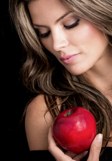 Beauty female portrait holding an apple - isolated over black background