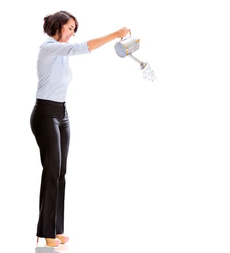 Business woman watering something - isolated over a white background