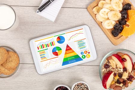 healthy eating concept - close up of tablet with several dieting statistics