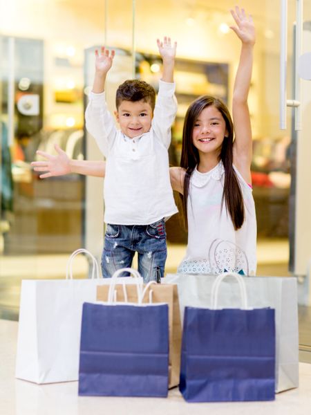 Shopping kids with arms up looking very happy