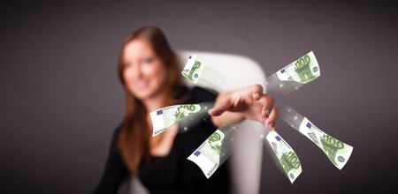 Pretty young woman sitting and throwing money