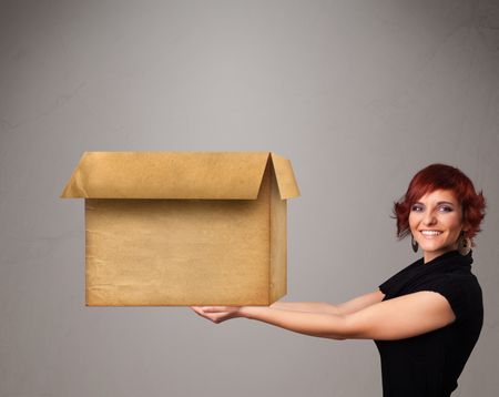 Beautiful young woman holding an empty cardboard box