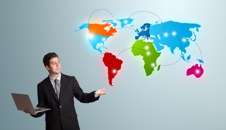 Handsome young man holding a laptop and presenting colorful world map