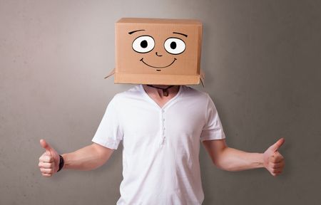 Young boy standing and gesturing with a cardboard box on his head