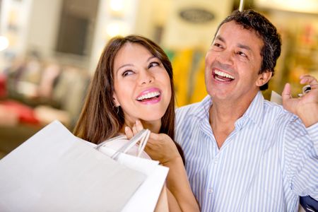 Happy couple at a shopping center holding bags