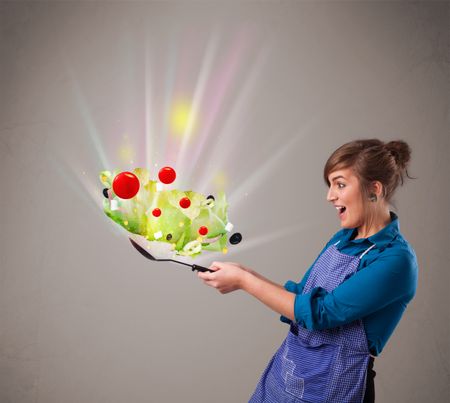 Beautiful young woman cooking fresh vegetables with abstract lights