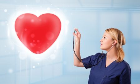 Pretty young nurse healing a red heart