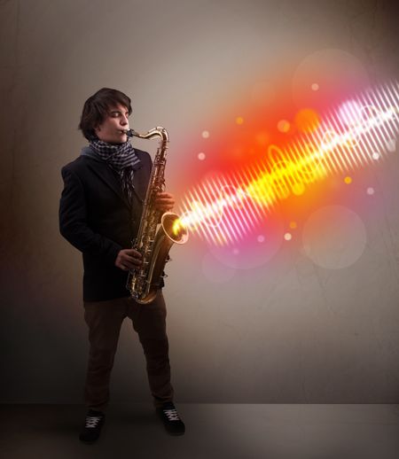 Attractive young man playing on saxophone with colorful sound waves