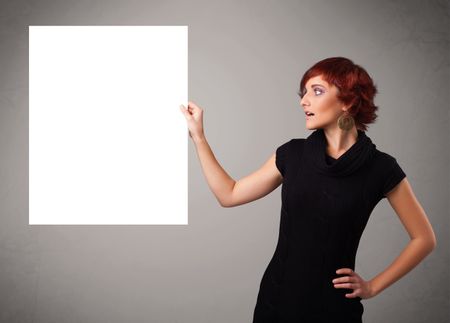 Pretty young woman presenting white paper copy space