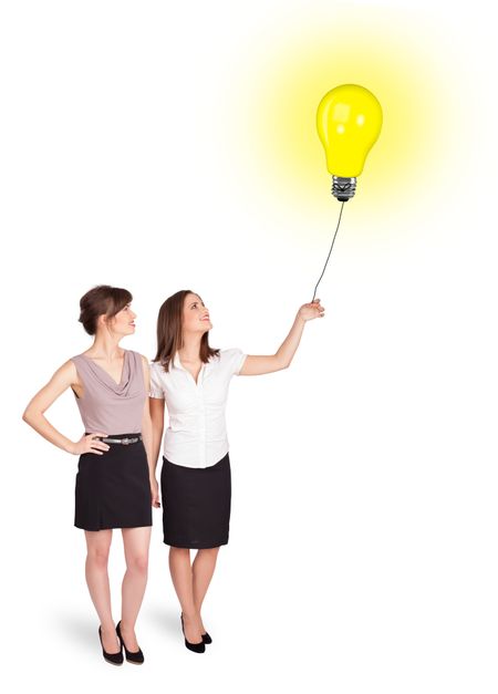 Happy young women holding a light bulb balloon