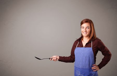 Beautiful young woman holding a spoon