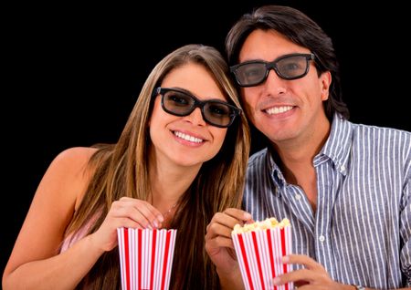 Happy couple watching a 3D movie and wearing glasses